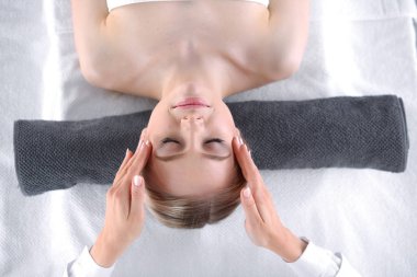 Masaj masasında uzanmış gözleri kapalı rahatlayan genç bir kadın. - Kadın. Spa salonu