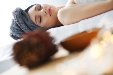 Masaj masasında uzanmış gözleri kapalı rahatlayan genç bir kadın. - Kadın. Spa salonu