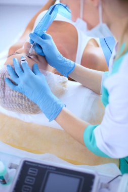 Kaşlar için kalıcı makyaj. Güzellik salonunda kalın kaşlı güzel bir kadın..