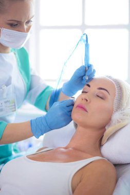 Kaşlar için kalıcı makyaj. Güzellik salonunda kalın kaşlı güzel bir kadın..