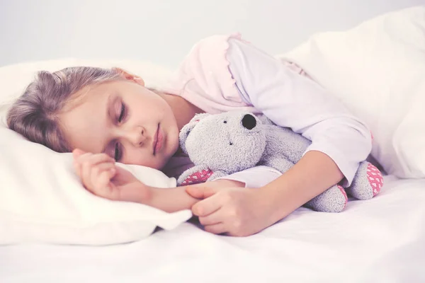 子供グッズ テディベアとベッドで眠る少女. — ストック写真