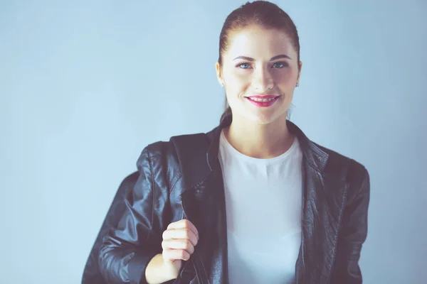 Portrait of beautiful young brunette woman in stylish black jacket on gray. — Stock Photo, Image