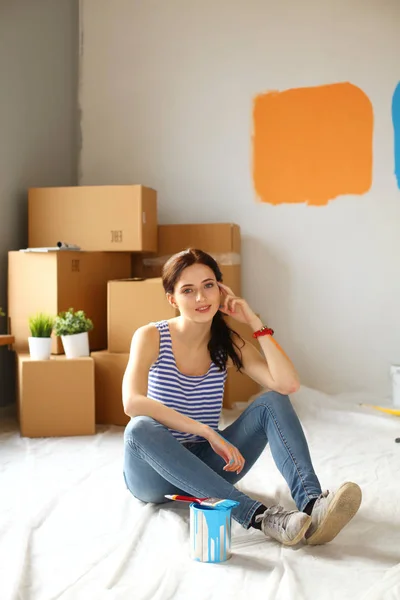 Feliz mulher sorridente pintando parede interior da nova casa. Feliz mulher sorridente — Fotografia de Stock