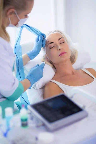 Permanent makeup for eyebrows. Closeup of beautiful woman with thick brows in beauty salon. — Stock Photo, Image