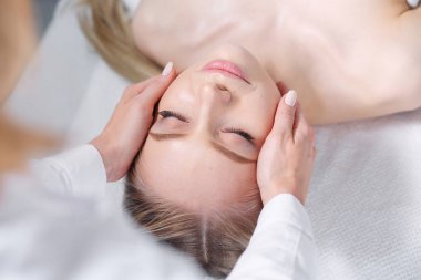 Masaj masasında uzanmış gözleri kapalı rahatlayan genç bir kadın. - Kadın. Spa salonu