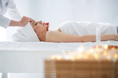 Masaj masasında uzanmış gözleri kapalı rahatlayan genç bir kadın. - Kadın. Spa salonu