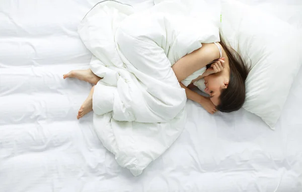 Jonge vrouwelijke gevoel pijn in bed. — Stockfoto