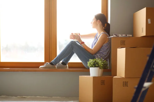 Femme dans une nouvelle maison avec des boîtes en carton. Femme dans la maison. — Photo