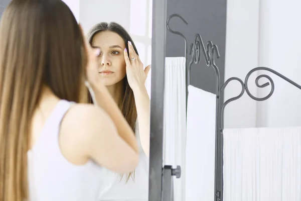 Jovem mulher olhando-se reflexão no espelho em casa . — Fotografia de Stock