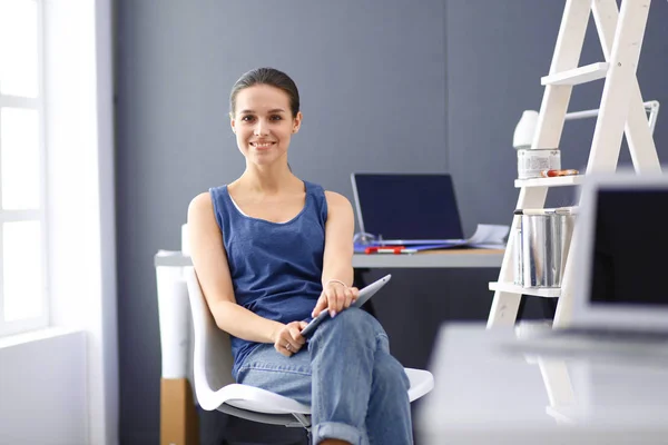 Giovane donna seduta alla scrivania con strumenti, piano e laptop. — Foto Stock