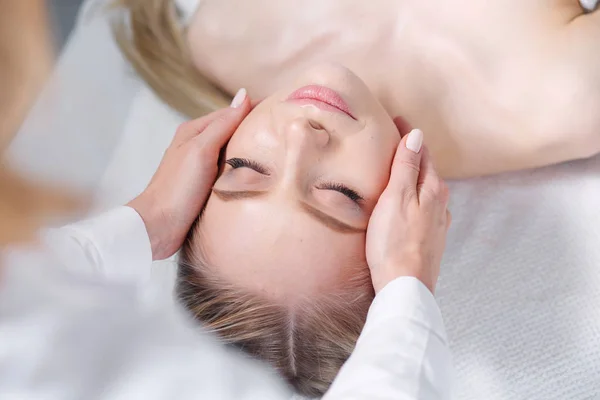 Jeune femme allongée sur une table de massage, relaxante les yeux fermés. Femme. Salon de spa — Photo