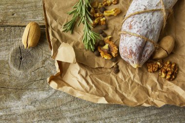 İtalyan salamı, deniz tuzu, biberiye, sarımsak ve fındık. Kırsal tarzda. Üst görünüm.