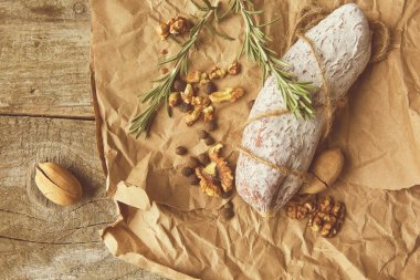 İtalyan salamı, deniz tuzu, biberiye, sarımsak ve fındık. Kırsal tarzda. Üst görünüm.