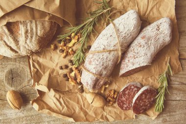 İtalyan salamı, deniz tuzu, biberiye, sarımsak ve fındık. Kırsal tarzda. Üst görünüm.