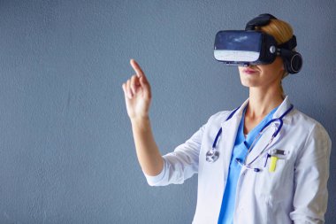 Sanal gerçeklik gözlüğü takan kadın doktor beyaz arka planda izole edilmiş..