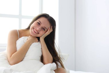 Güzel bir kadın yatağında uzanıyor..