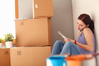 Kadın seçerek boya rengi renk örneği yeni ev ahşap yere oturmak için. Kadın evde