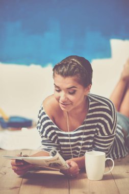 Duvar resmi yapıyor, merdiven üzerinde duran güzel ve genç birbayan. Güzel genç kadın