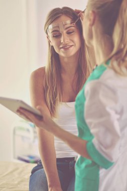 Kaşlar için kalıcı makyaj. Güzellik salonunda kalın kaşlı güzel bir kadın..