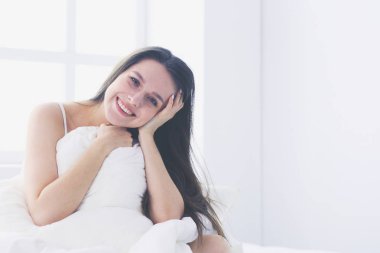 Güzel bir kadın yatağında uzanıyor..