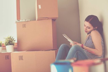 Kadın seçerek boya rengi renk örneği yeni ev ahşap yere oturmak için. Kadın evde