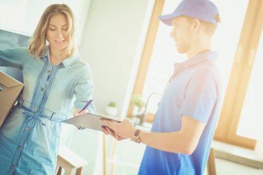 Mavi üniformalı gülümseyen kurye servis konseptine paket kutusu teslim eden teslimatçı. Mavi üniformalı gülümseyen teslimatçı.