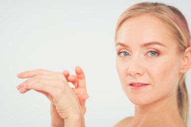 güzel genç kız temiz bir cilt bir el ile bir yanak dokunur.