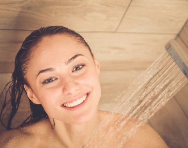 Genç beautyful kadın banyoda duş altında.