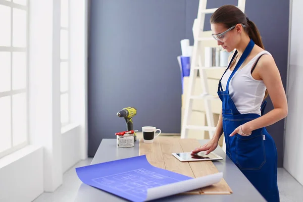 Ung kvinna stående medan stående ny lägenhet . — Stockfoto