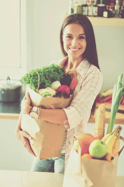 野菜の入った食料品の買い物袋を持っている若い女性。若い女性 — ストック写真