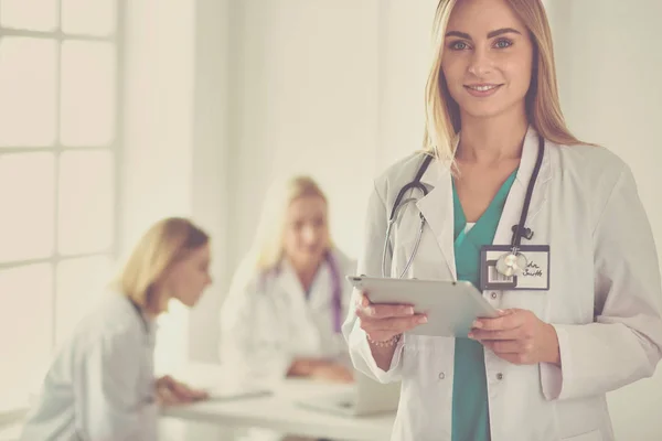 Retrato de una joven doctora, con almohadillas en la mano, en un consultorio médico — Foto de Stock