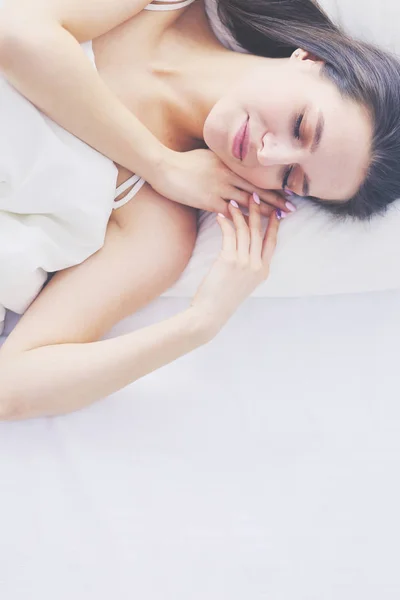 Hermosa chica duerme en el dormitorio, acostado en la cama . — Foto de Stock