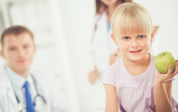 Dítě a medicína koncept - lékařka dává jablko malé holčičce. Koncept dítěte a medicína — Stock fotografie