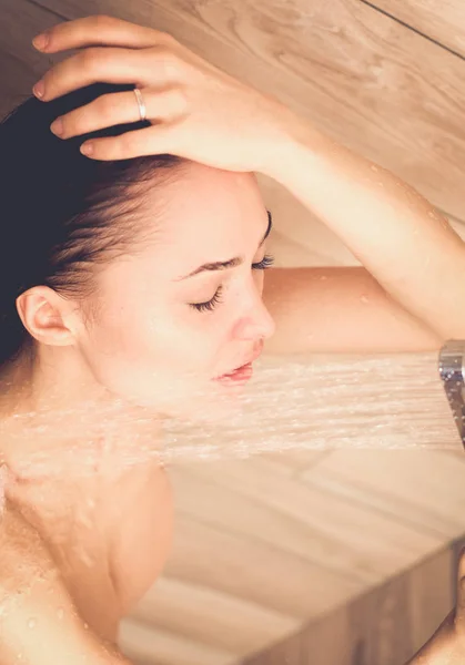 Junge schöne Frau unter der Dusche im Badezimmer. — Stockfoto