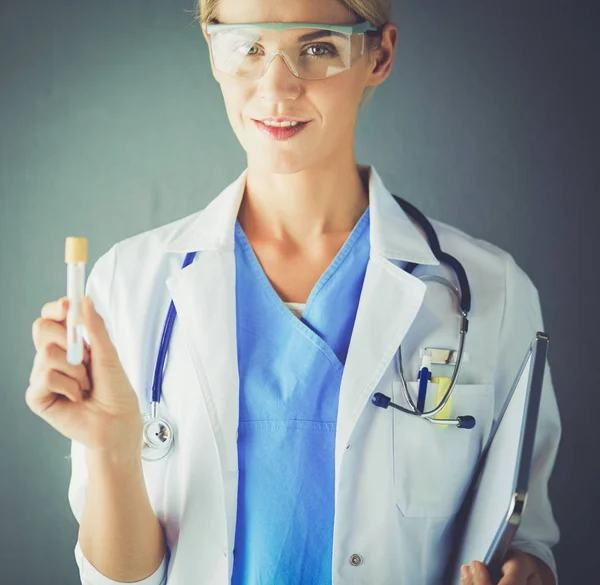 Female medical or research scientist or doctor using looking at a test tube of clear solution in a lab or laboratory. — Stock Photo, Image