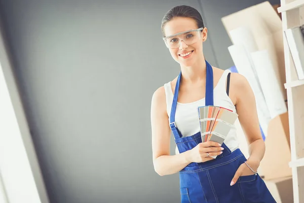 Jovem segurando uma amostra de cor com uma pintura de pintor — Fotografia de Stock