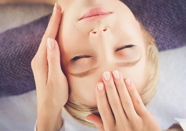 Ung kvinna liggande på ett massagebord, avslappnande med slutna ögon. Kvinnan. Spasalong — Stockfoto