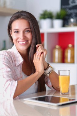 Mutfakta ipad 'ini kullanan genç bir kadın. Genç kadın.