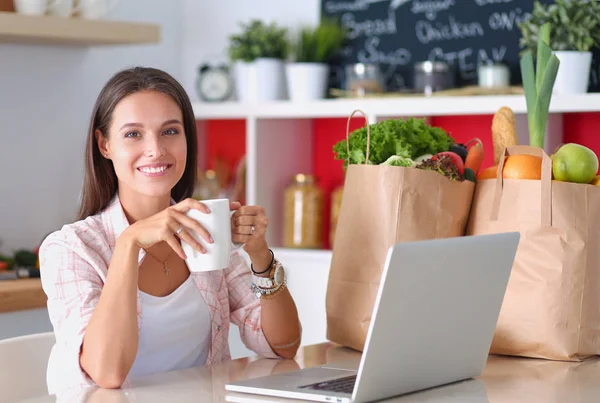 Lächelnde Frau beim Online-Shopping mit Tablet und Kreditkarte in der Küche. Lächelnde Frau — Stockfoto