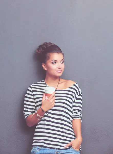 Jeune femme debout avec tasse, isolée sur fond gris. Jeune femme — Photo