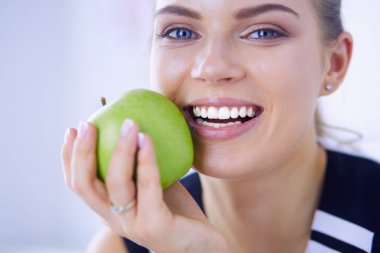 Yeşil elmalı, sağlıklı, gülümseyen bir kadının portresi..