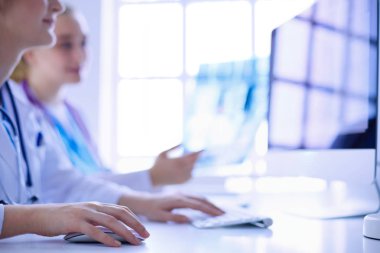 Kadın doktorlar hastanede röntgen görüntülerini inceliyor ve tartışıyorlar..