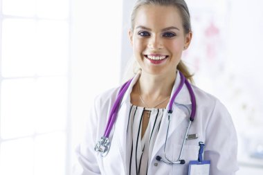 Üniformalı tıbbi bir steteskopla gülümseyen kadın doktor.