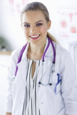 Üniformalı tıbbi bir steteskopla gülümseyen kadın doktor.