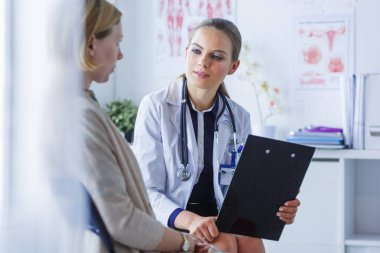 Doktor ve hasta masada otururken bir şey tartışıyorlar. İlaç ve sağlık hizmetleri kavramı