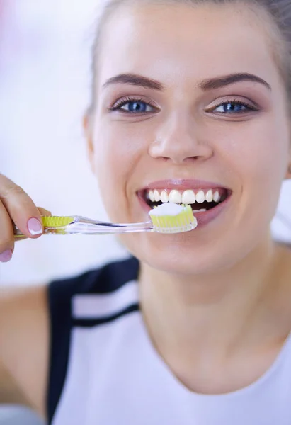 Joven chica bonita manteniendo la higiene bucal con cepillo de dientes . — Foto de Stock