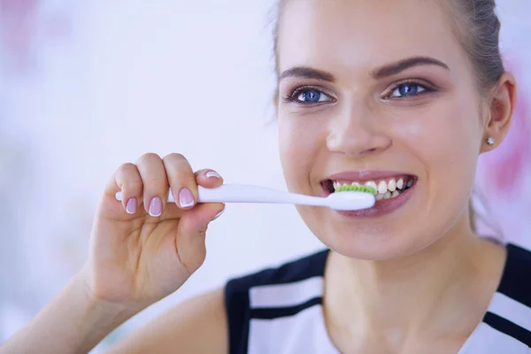 Junges hübsches Mädchen pflegt Mundhygiene mit Zahnbürste. — Stockfoto