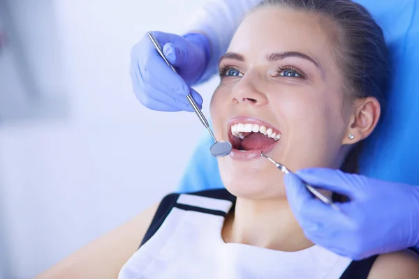 Mujer joven con la boca abierta examinando la inspección dental en el consultorio del dentista. — Foto de Stock