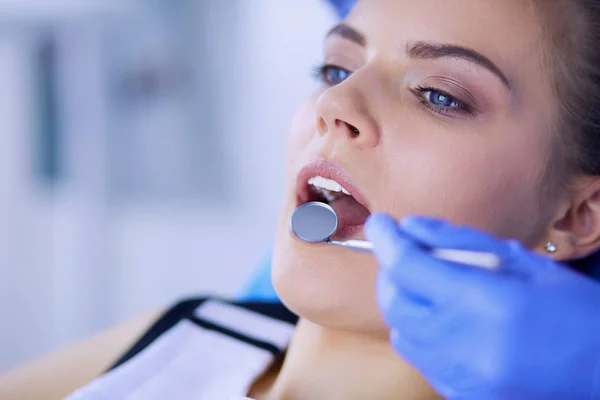 Mujer joven con la boca abierta examinando la inspección dental en el consultorio del dentista. — Foto de Stock