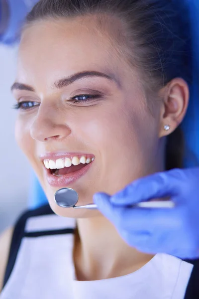 Mujer joven con la boca abierta examinando la inspección dental en el consultorio del dentista. — Foto de Stock